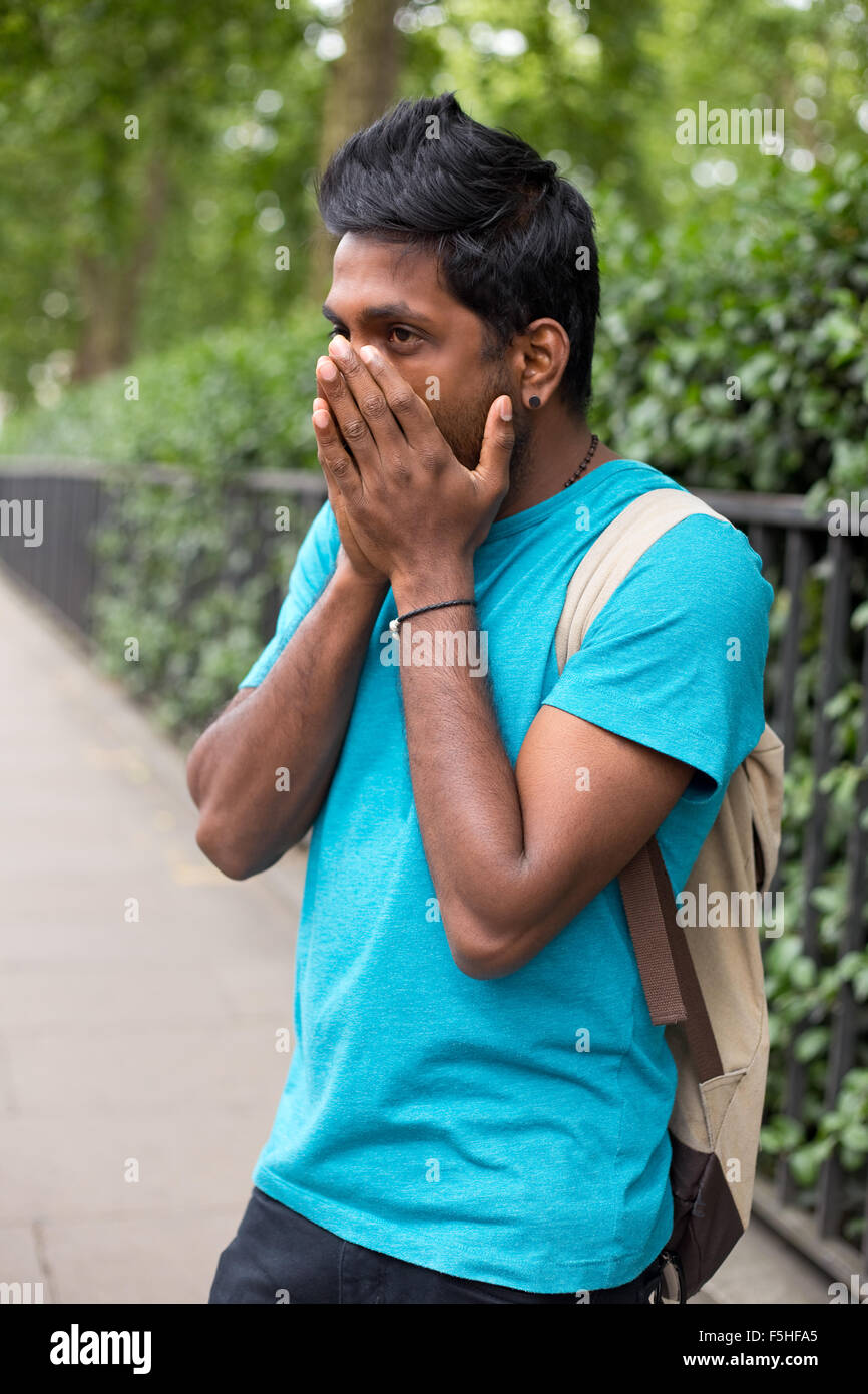 young indian man in the street looking worried Stock Photo