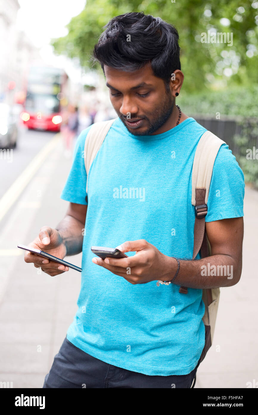 young man holding two phones Stock Photo
