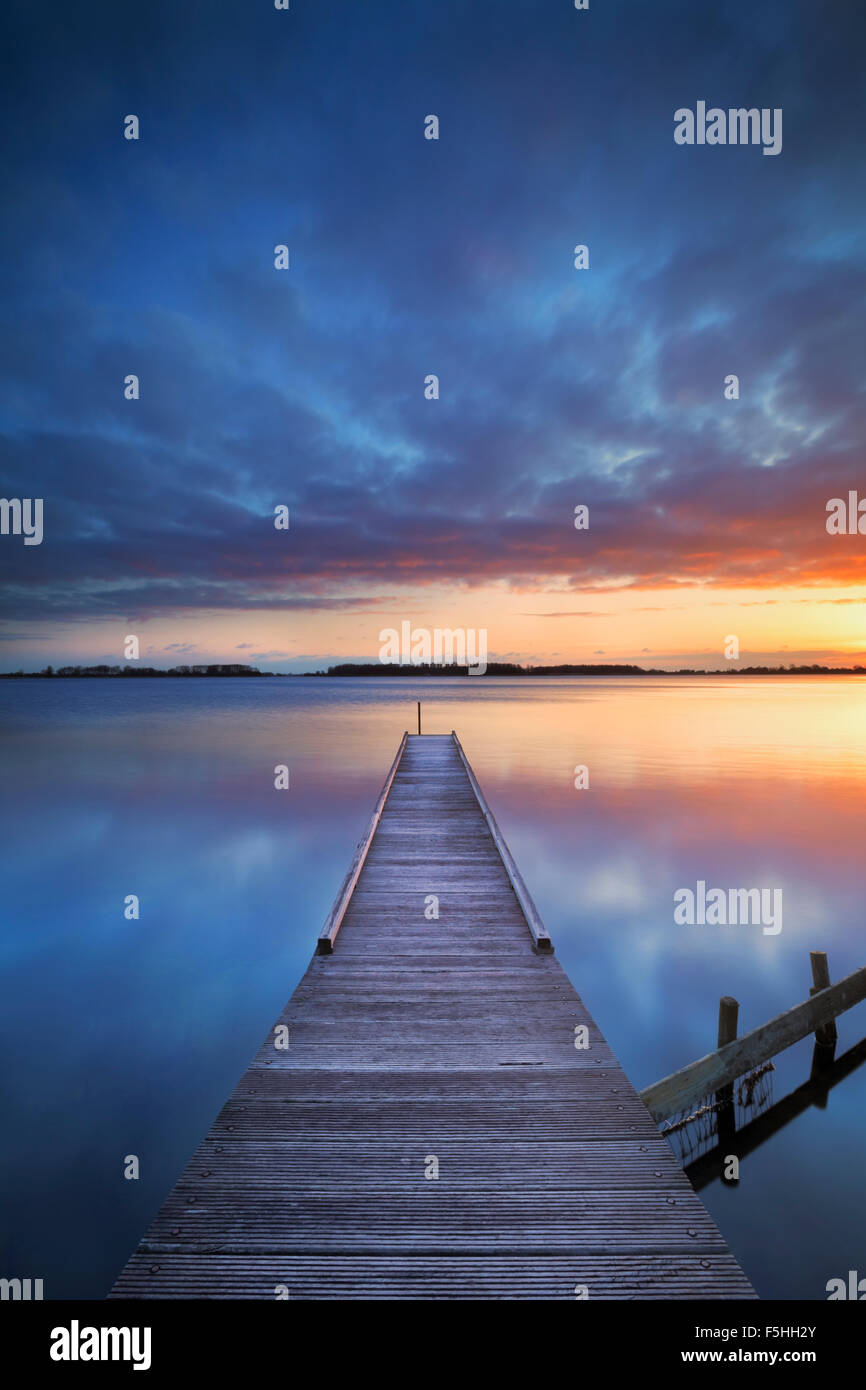 A small jetty on a lake at sunrise. Photographed near Amsterdam in The Netherlands. Stock Photo