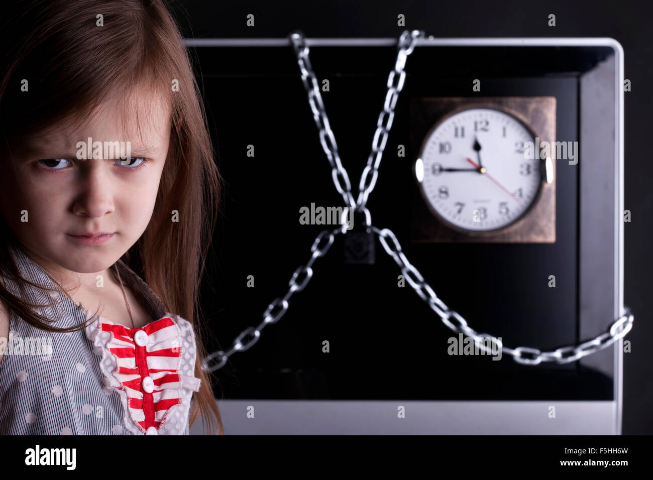 Young girl, TV closed with chain lock, clock Stock Photo