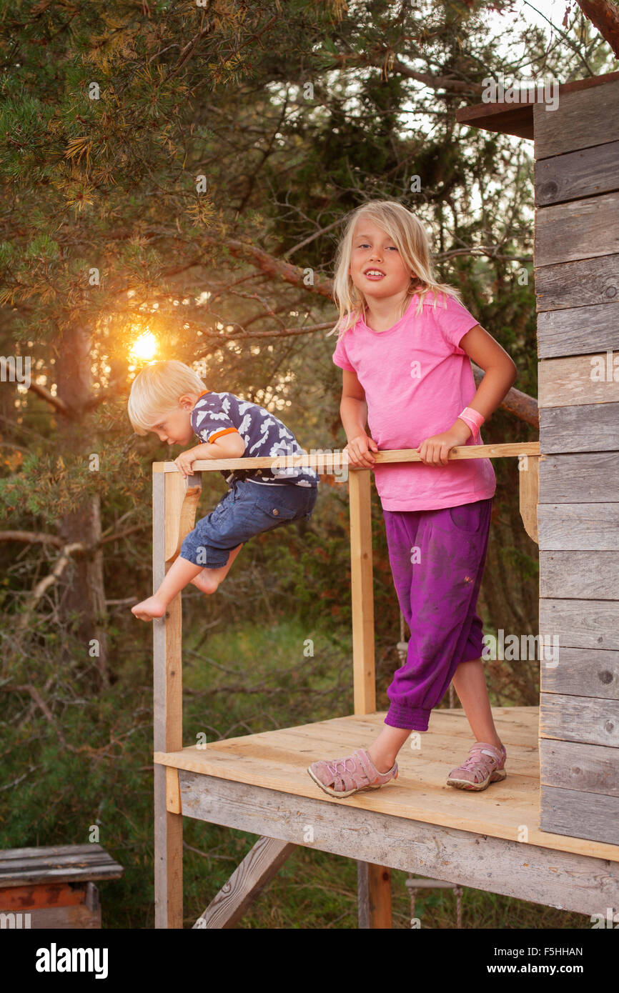 Sweden, Gotland, Faro, Girl (8-9) with brother (2-3) at tree house porch Stock Photo