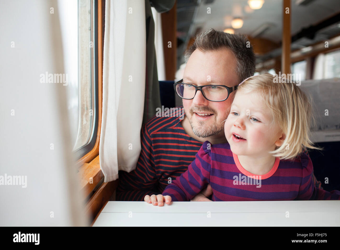 Sweden, Father and daughter (2-3) traveling by train Stock Photo