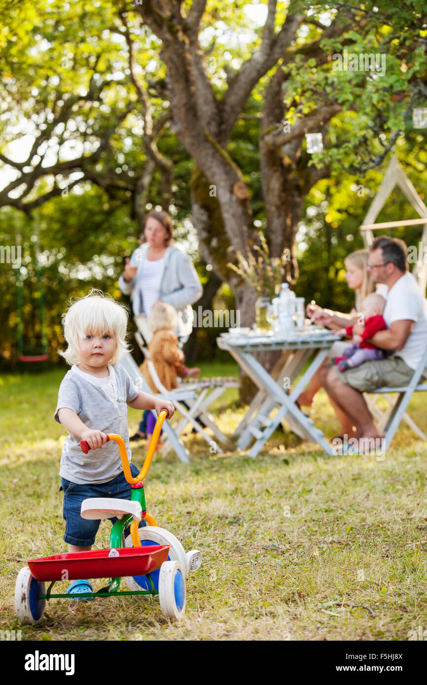Sweden, Gotland, Havdhem, Family with three children (12-17 months, 2-3) in backyard Stock Photo