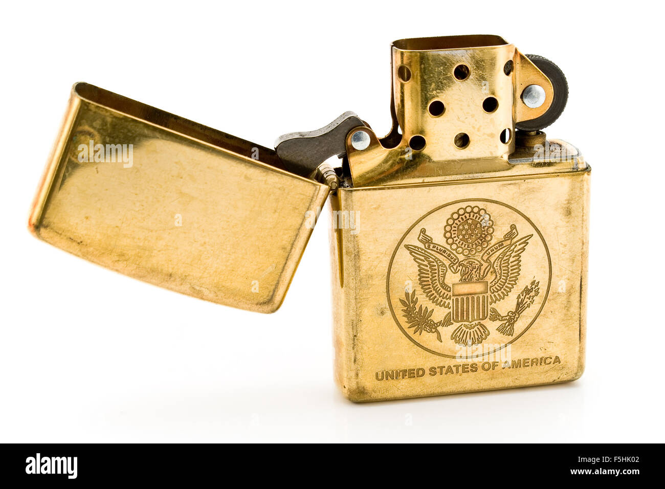 Golden lighter with carved United States seal isolated on  white Stock Photo