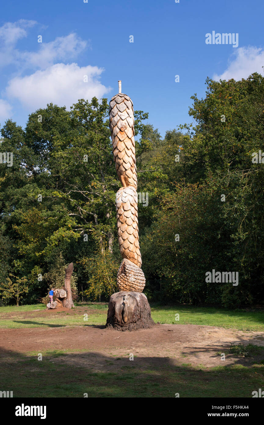Dead pine tree trunk sculpted into pine cones at RHS Wisley Gardens. Surrey, England Stock Photo