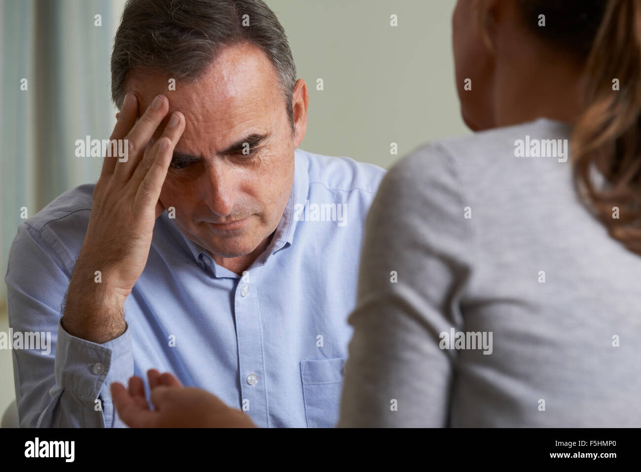 Depressed Mature Man Talking To Counsellor Stock Photo