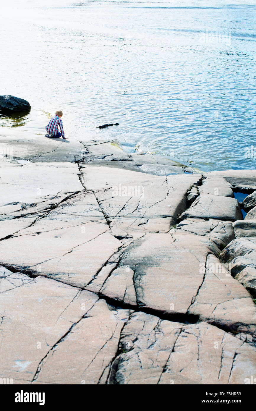 Sweden, Uppland, Oregrund, Boy (8-9) touching cold sea water Stock Photo
