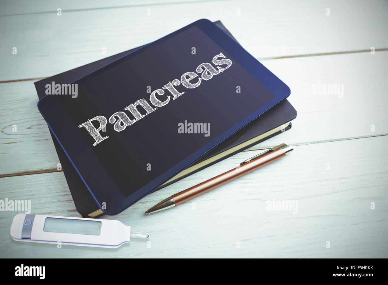 Pancreas against view of a book and tablet lying on desk Stock Photo