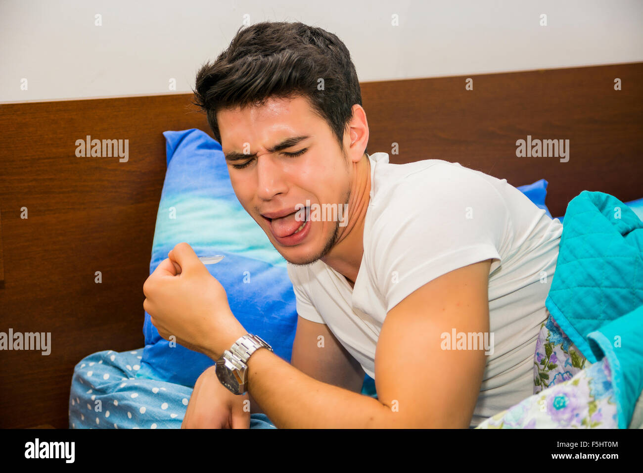 Close Up of Attractive Young Man Lying in Bed and Coughing, Disgusted