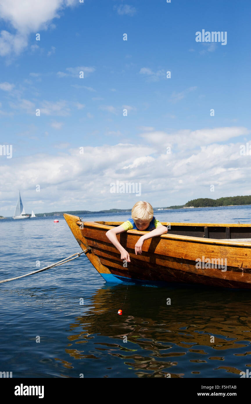 Sweden, Sodermanland, Stockholms Skargard, Dalaro, Boy (10-11) sitting in moored boat Stock Photo