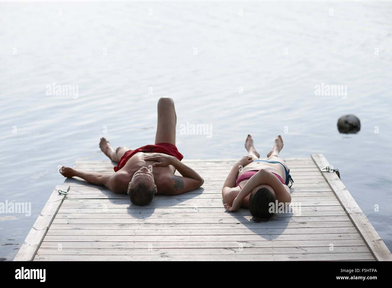 Sweden, Dalarna, Siljan, Man and woman lying on jetty Stock Photo