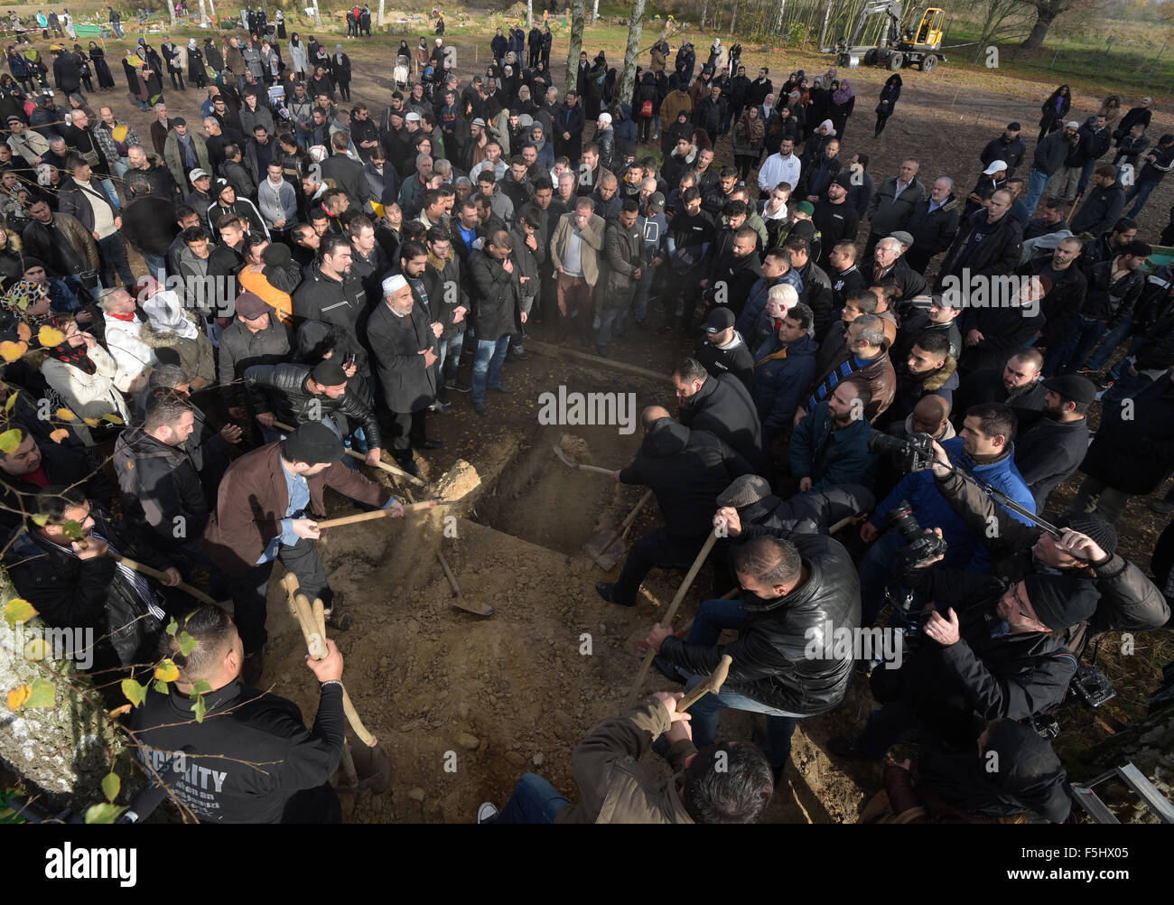 Berlin, Germany. 05th Nov, 2015. Mourners shovel dirt over the grave in