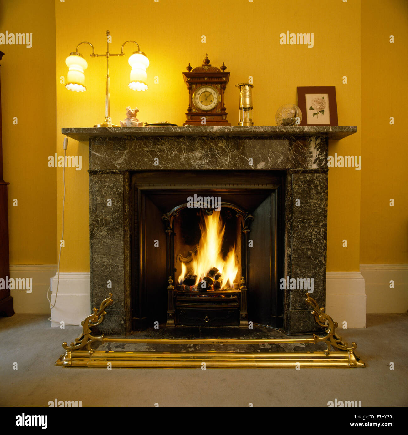 Lighted lamps on black marble fireplace Stock Photo