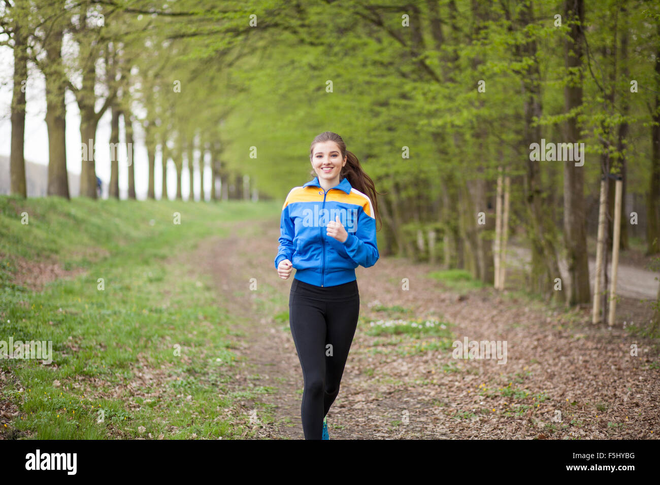 Young beautiful woman running on a trail Stock Photo - Alamy