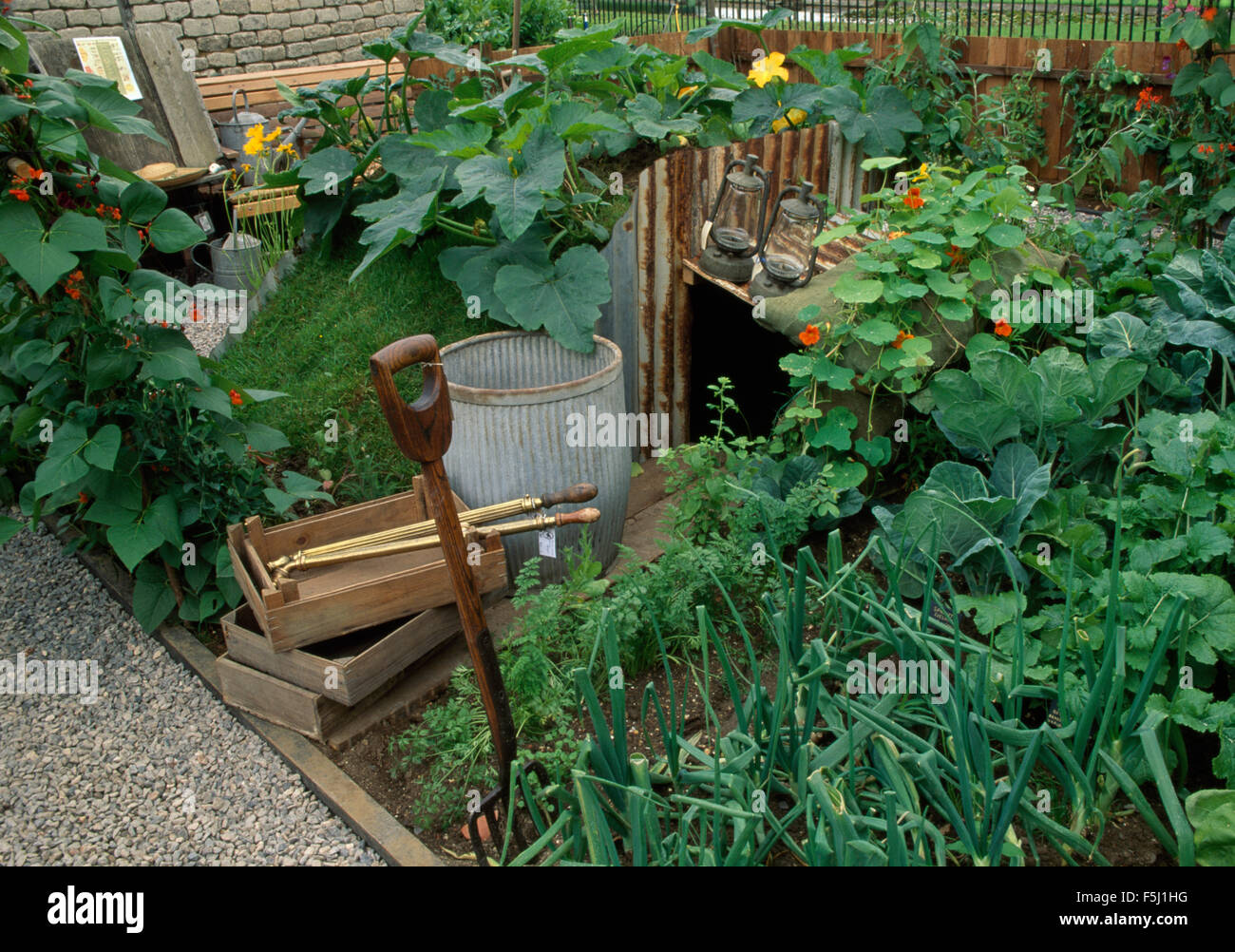 Old wooden boxes in vegetable garden with fork in bed with onions and cabbages Stock Photo