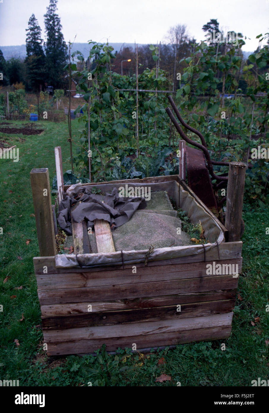 Compost heap edged with wooden boarding in large vegetable garden Stock Photo