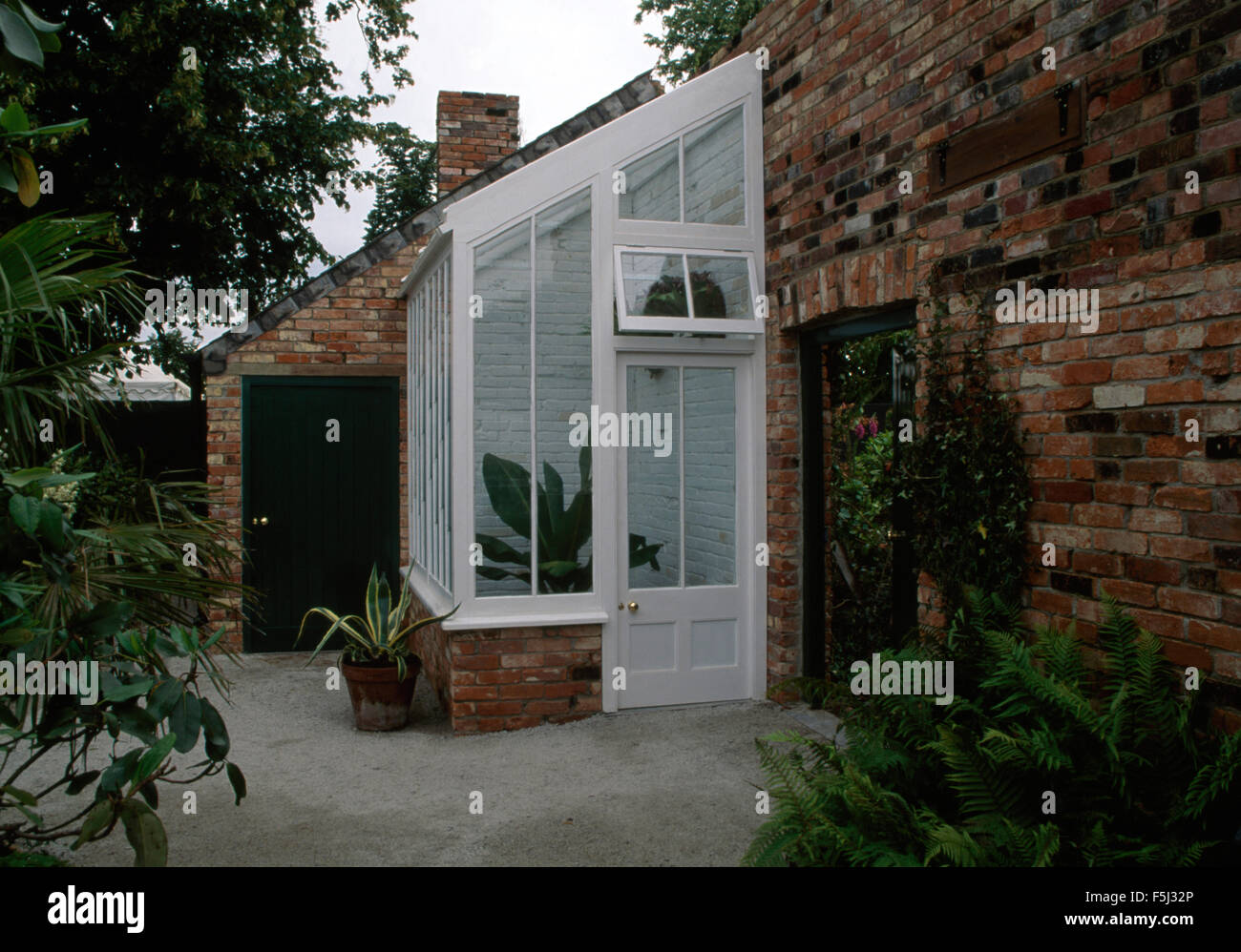 Back elevation of house with small greenhouse extension Stock Photo