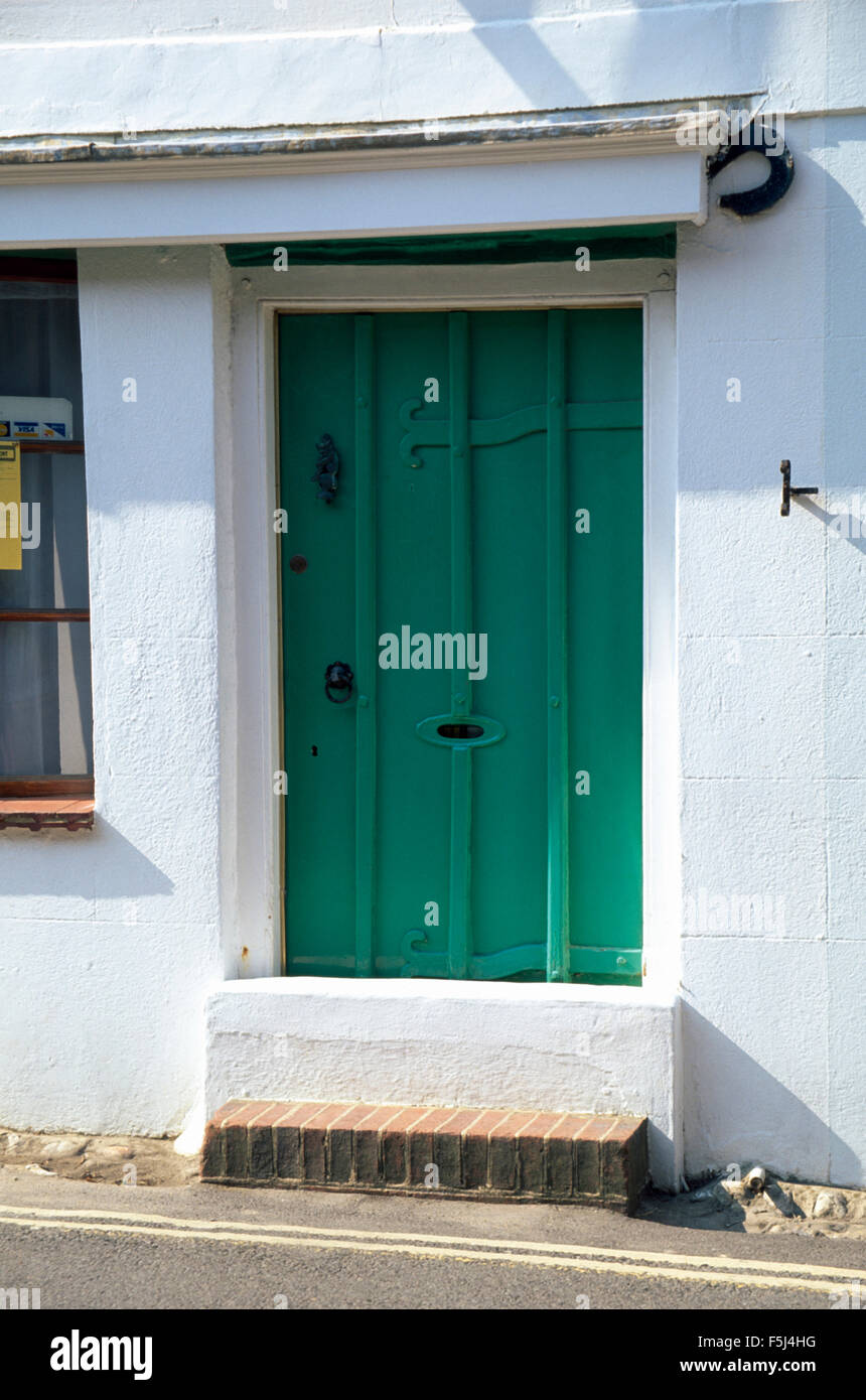 Exterior Of Small White Terraced Victorian Cottage With A Green