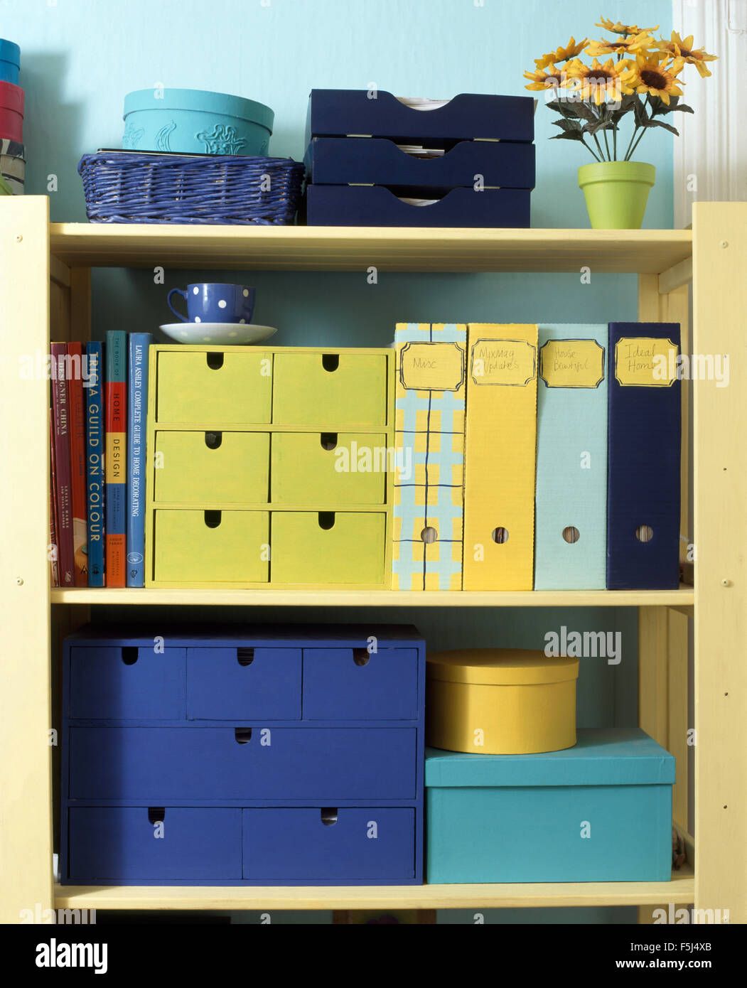 Close-up of brightly colored storage boxes and files on painted shelves in a nineties economy study bedroom Stock Photo