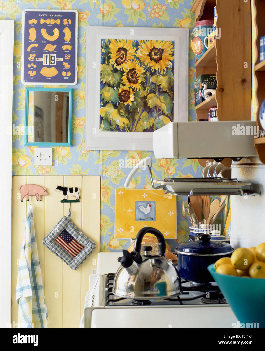 Yellow crockery in nineties economy kitchen with turquoise doors on fitted  units Stock Photo - Alamy