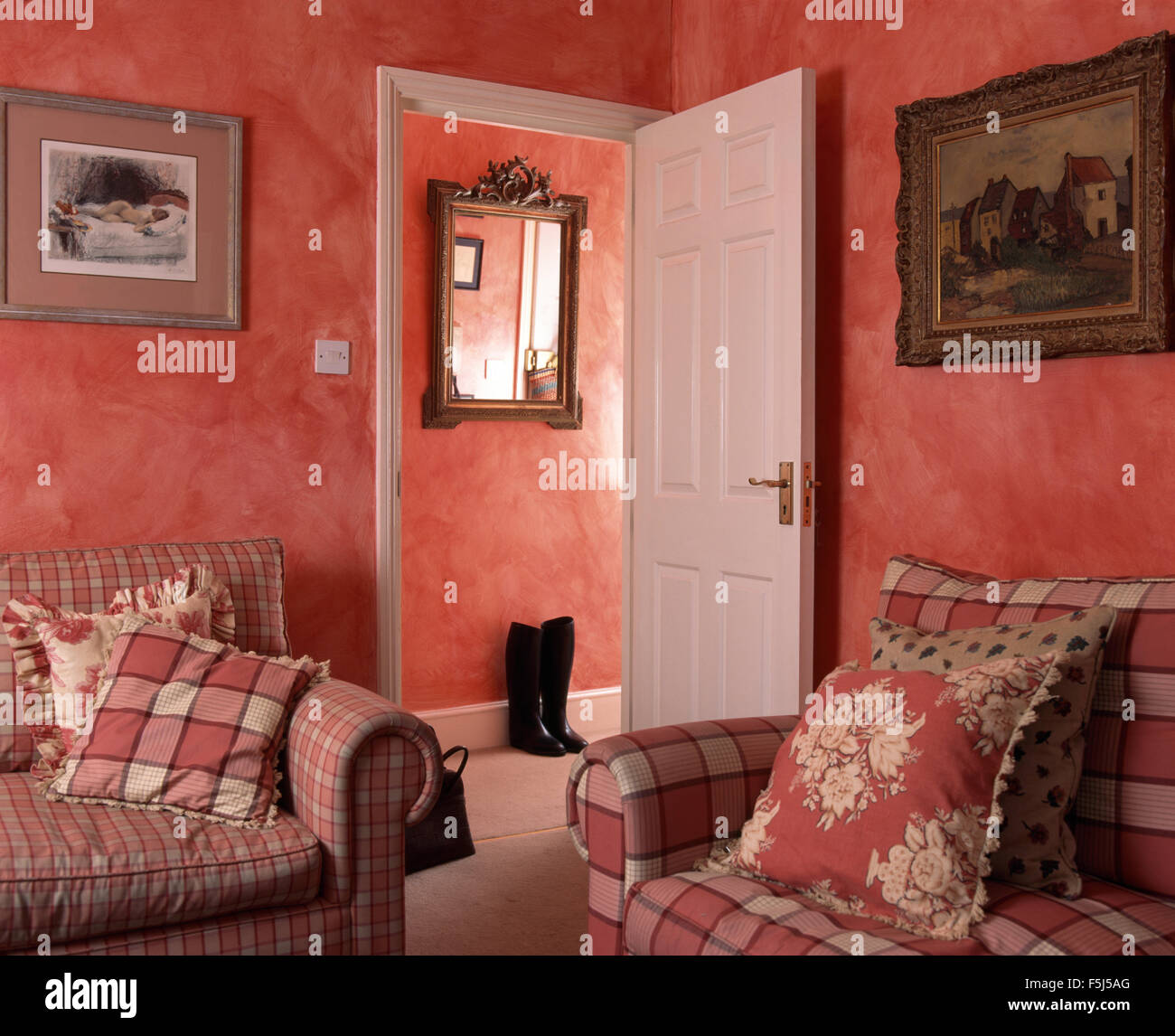 Red checked sofas with toning cushions in a red living room