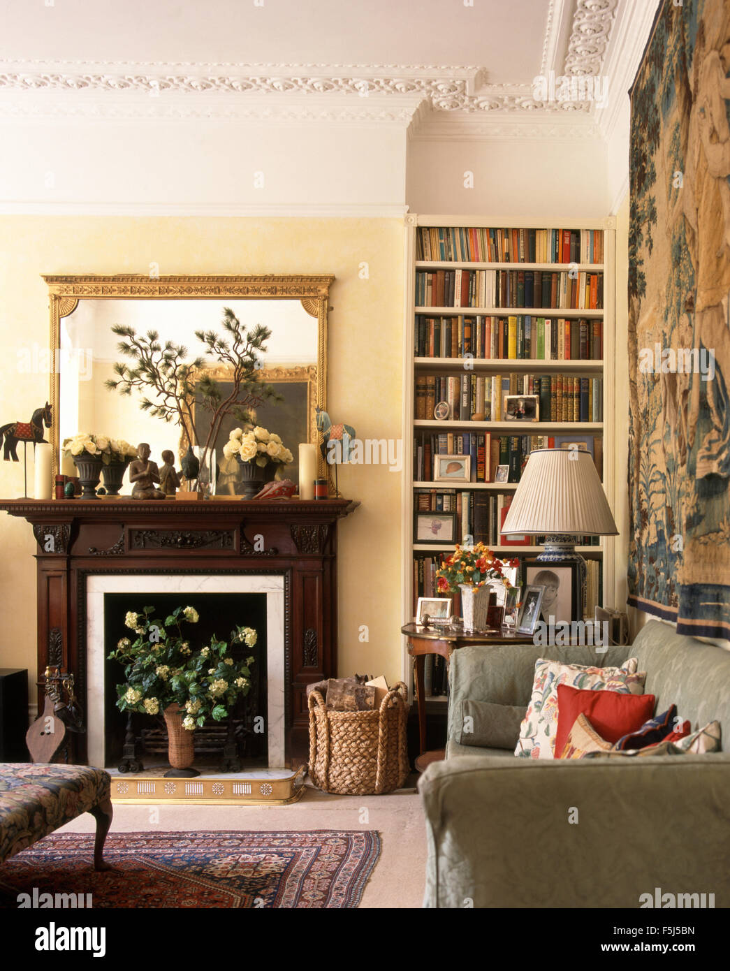 Gilt mirror above fireplace in a very traditional living room with ...