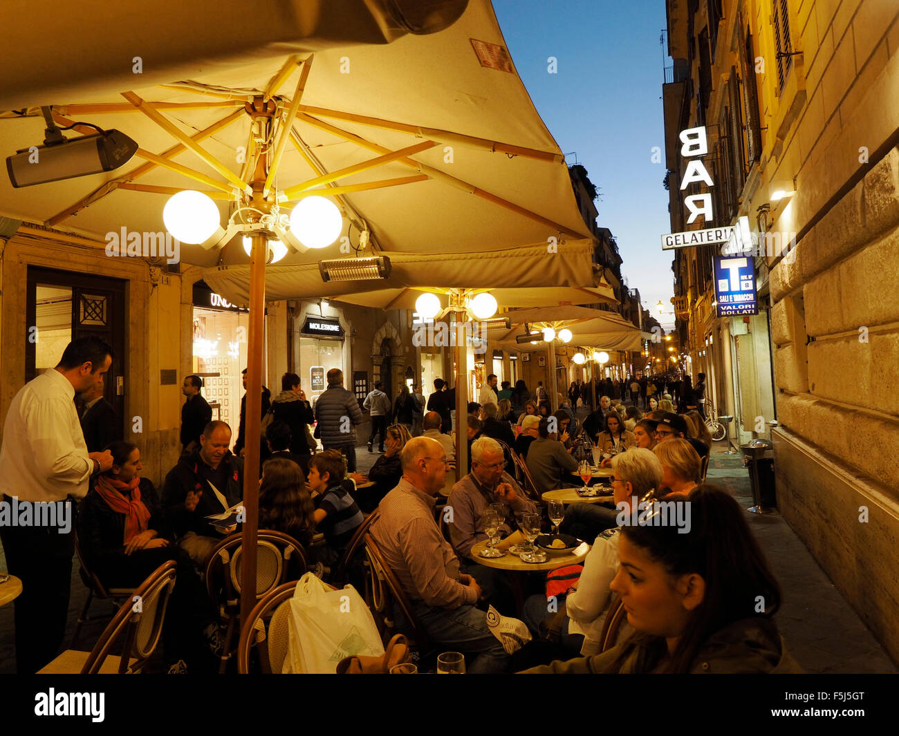 Via Frattina in the Rome shopping district near the Spanish steps, people sitting down for a drink. Stock Photo