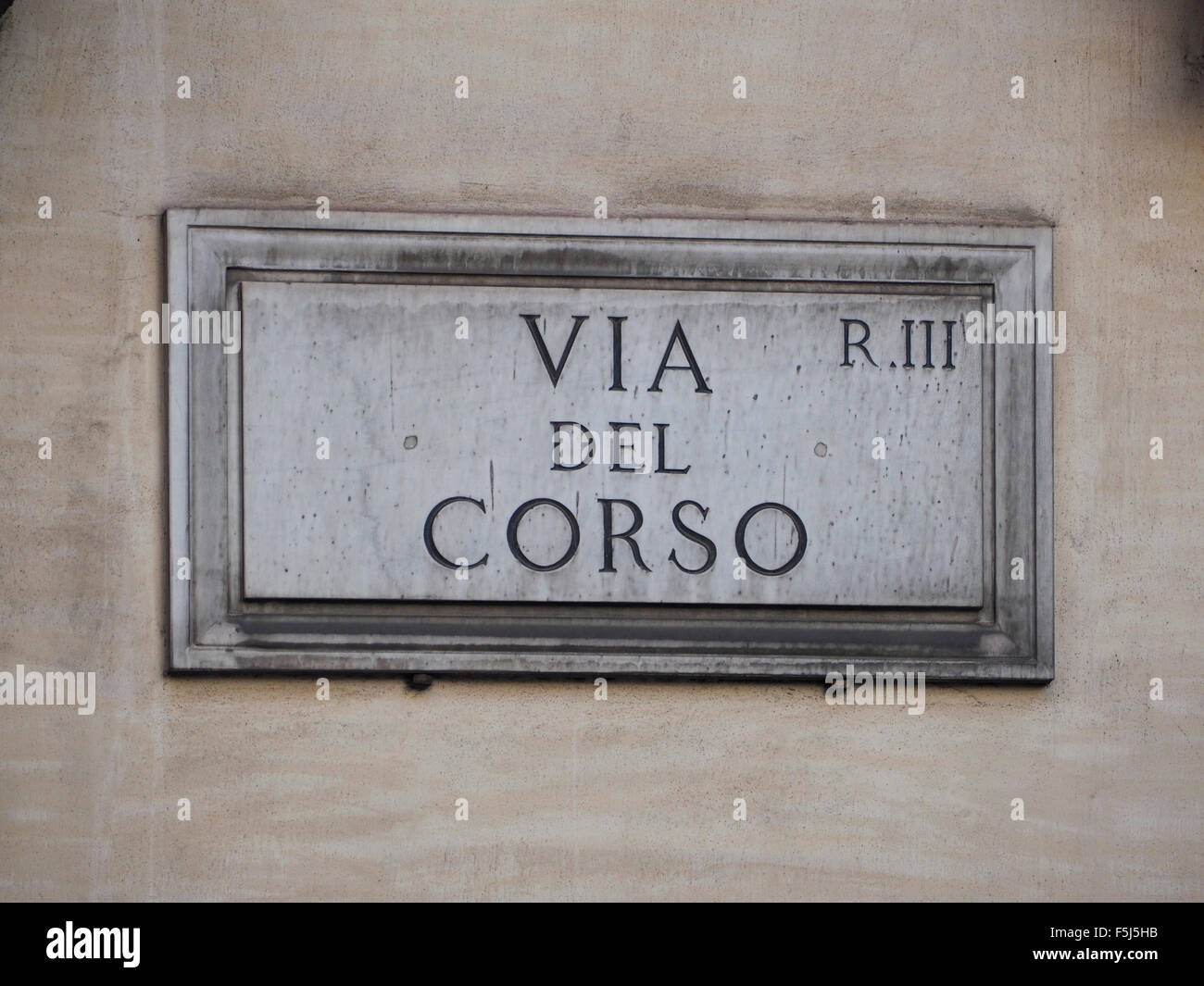Via del Corso street name sign in marble in Rome, Italy. The Via del Corso is the main shopping street in Rome. Stock Photo