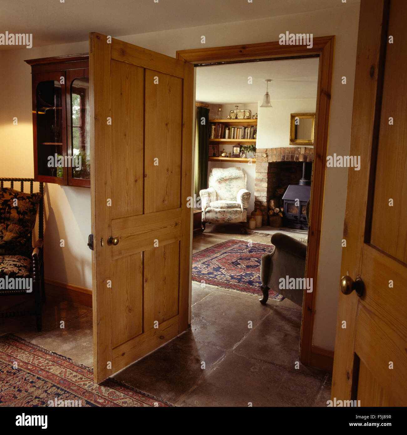 Eighties cottage dining room with a stripped pine door open to the sitting room Stock Photo