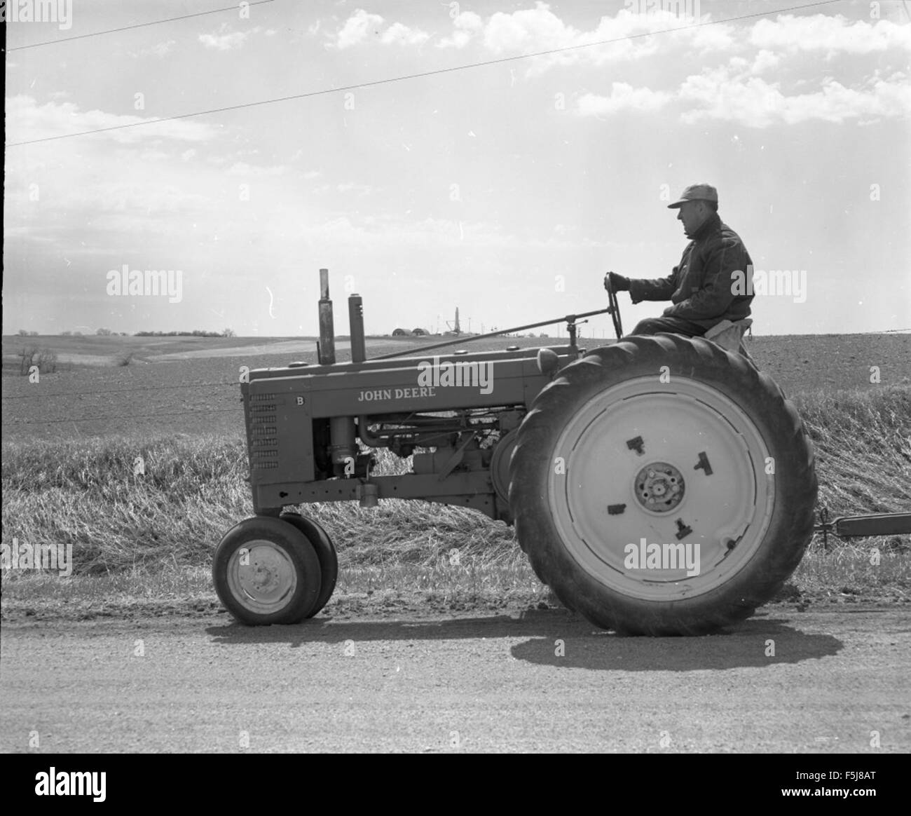 Atlas  551-9 Farmer Driving Tractor Down Road with Missile Stock Photo