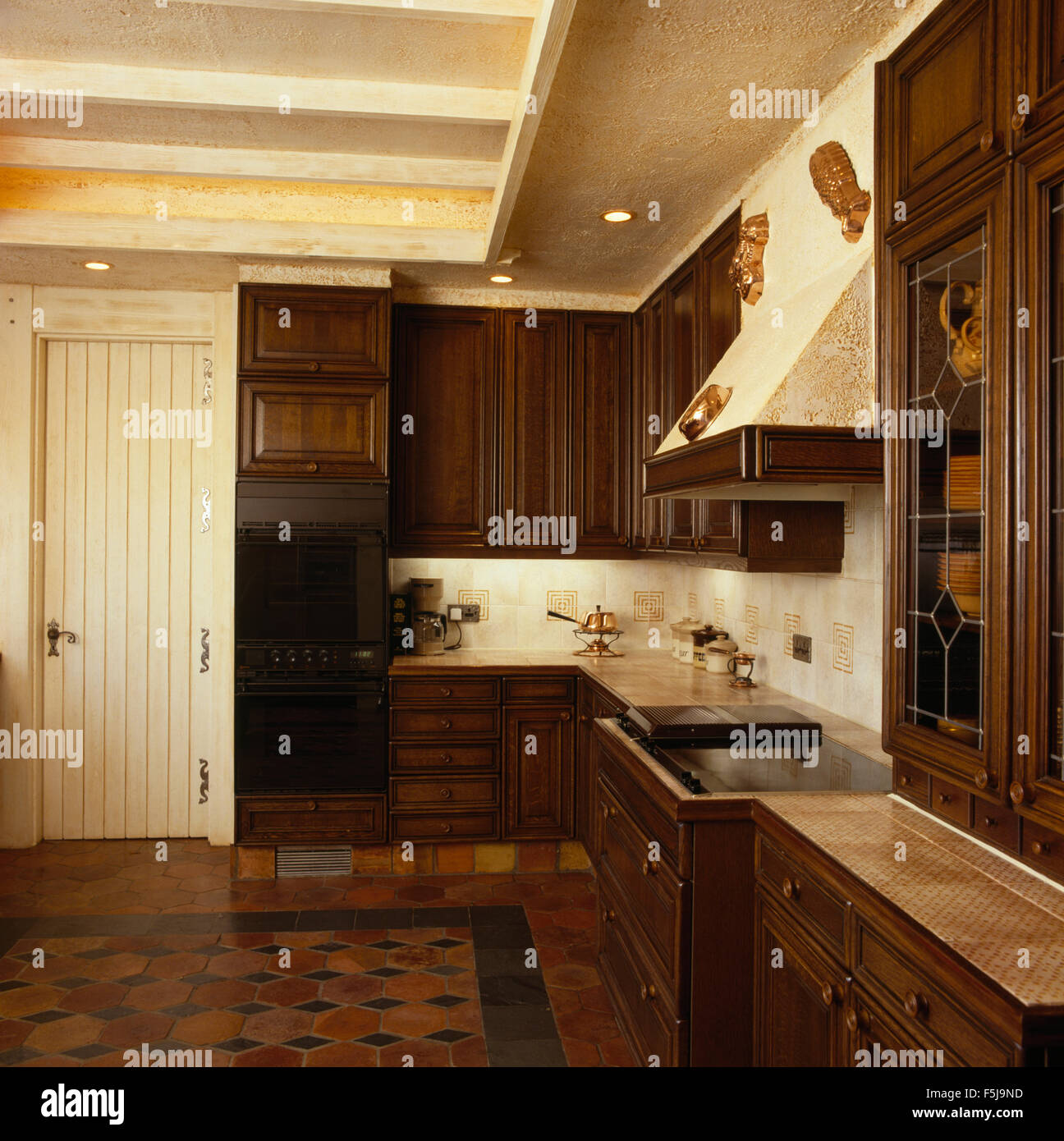 Dark wood fitted units in an eighties country kitchen Stock Photo