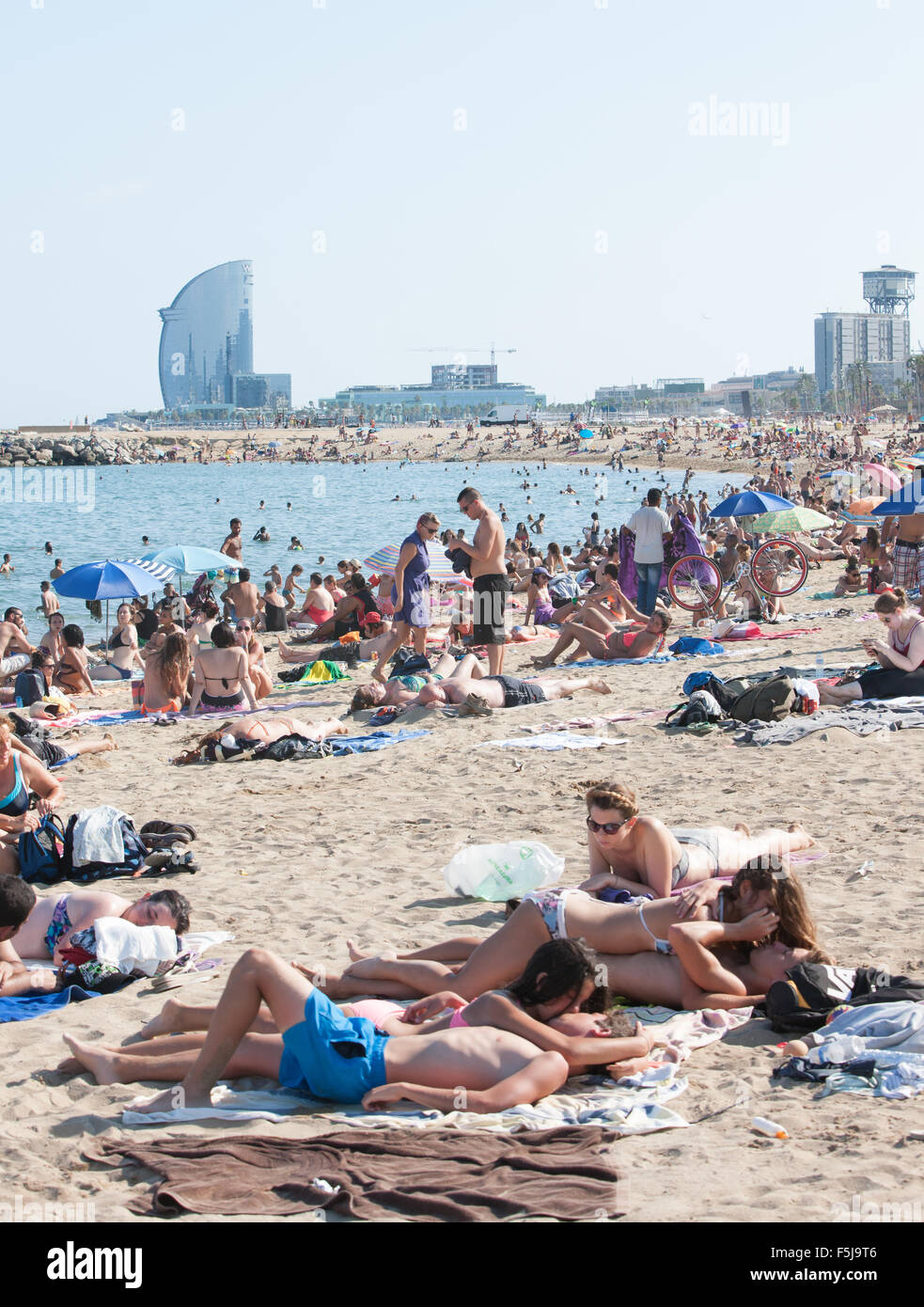 Sun bathing.Couples kissing at urban beach, Barceloneta,Barcelona.warning,danger,sunburn,sun,burnt,beach,Catalonia,Spain. Stock Photo