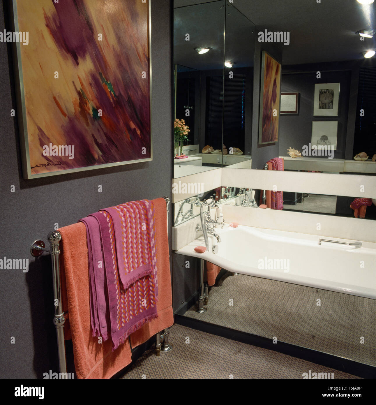 Painting above chrome towel rail with pink towels in an eighties