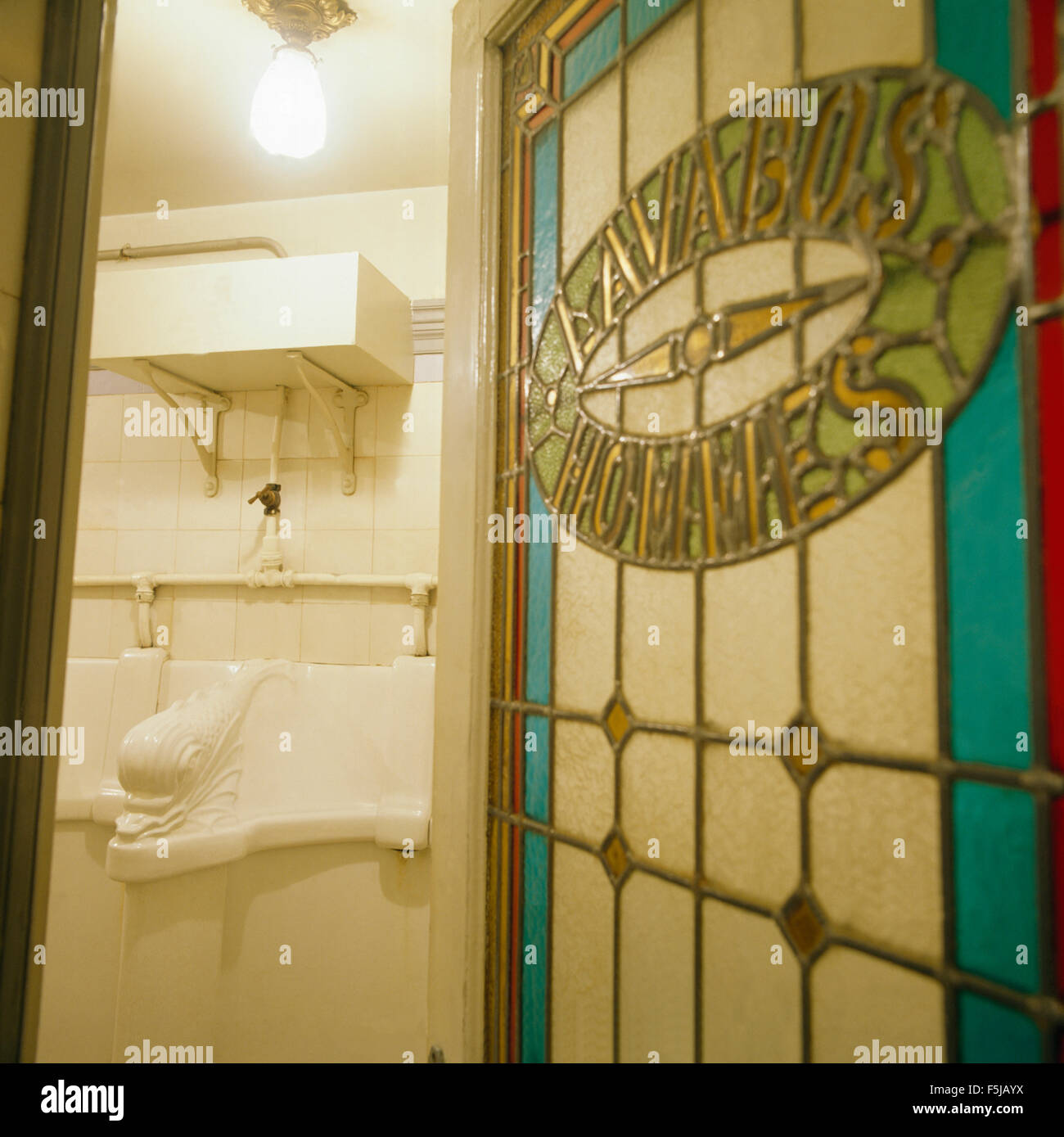 Art Nouveau stained glass door open to toilet in a restaurant in Paris Stock Photo