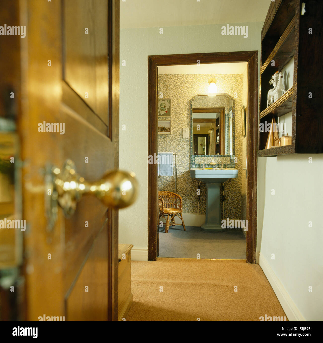Brass knob on door on landing with a view of the bathroom from seventies landing Stock Photo