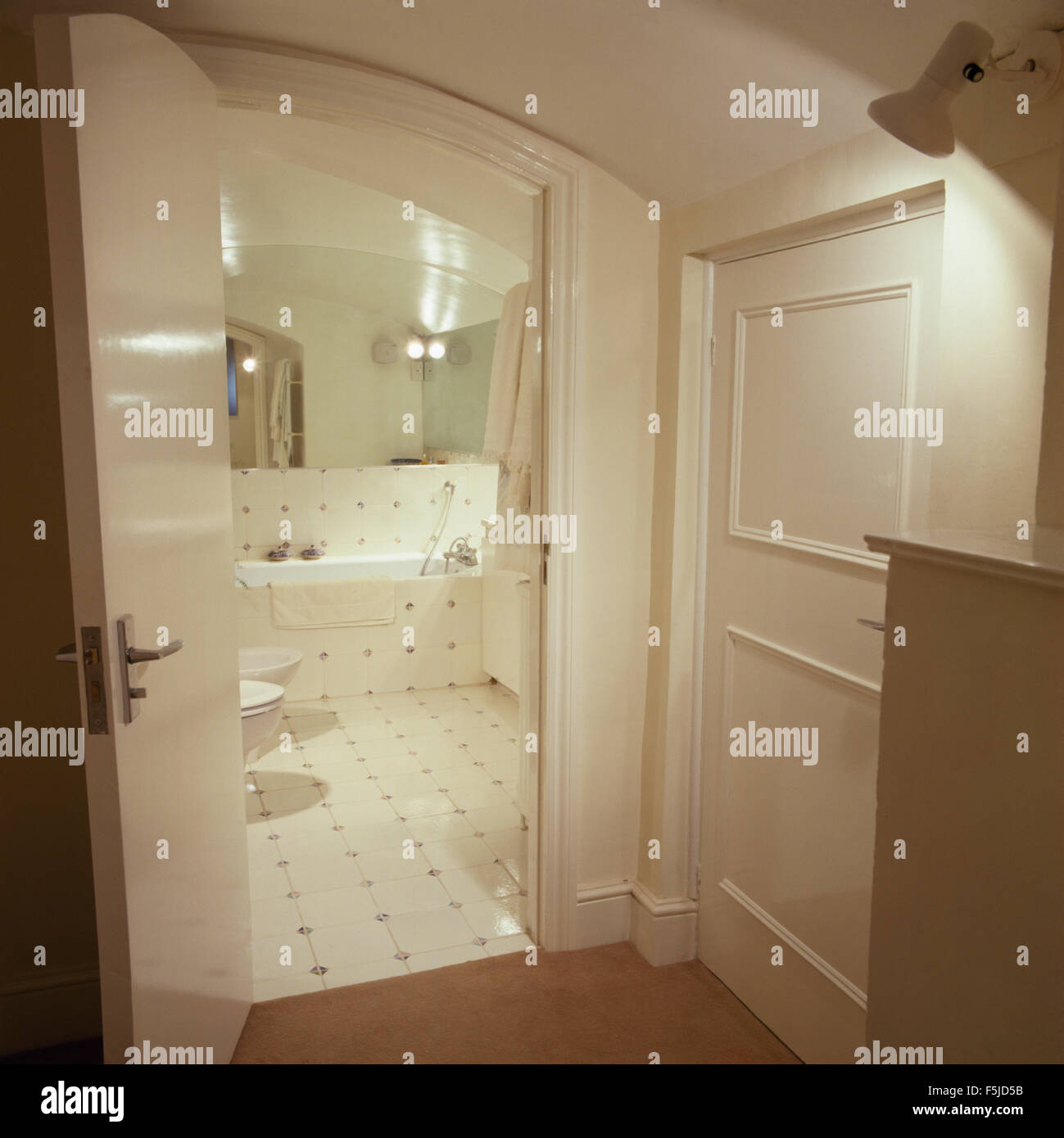 Door Open To White Tiled Eighties Basement Bathroom Stock