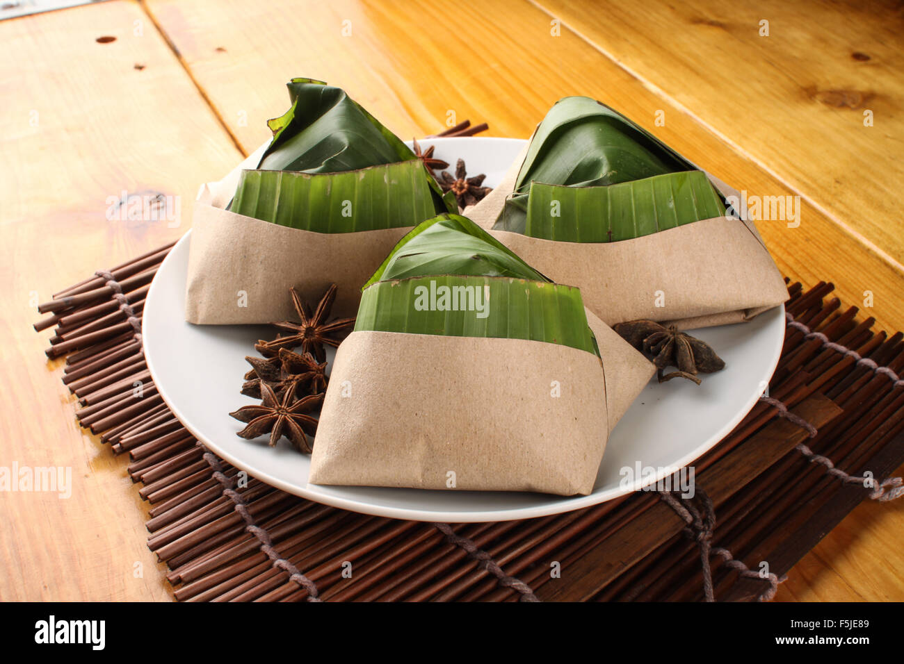 traditional fresh Malaysian nasi lemak packed with banana leaf in wood background Stock Photo