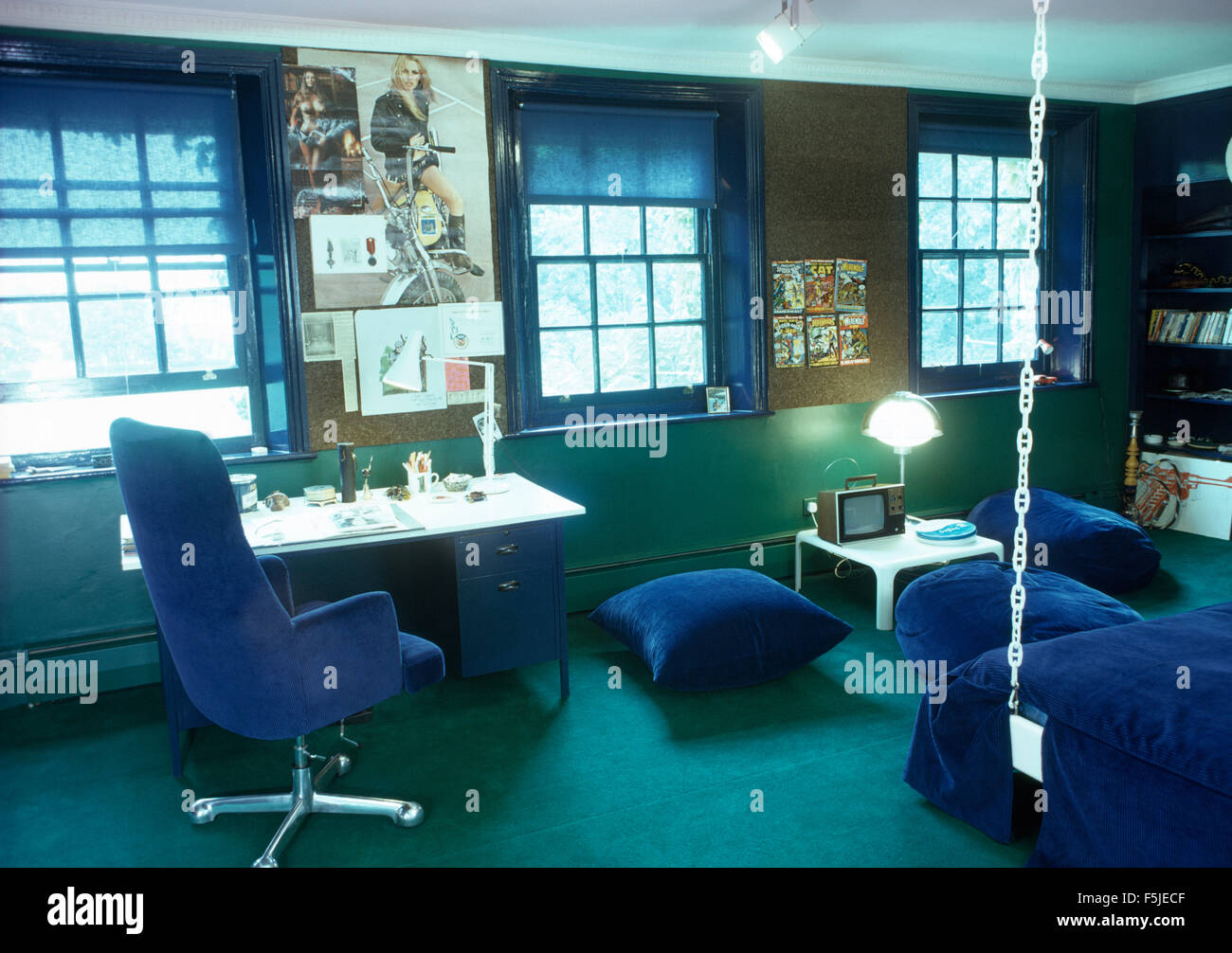 Blue velvet chair and floor cushions in a sixties bedroom Stock Photo