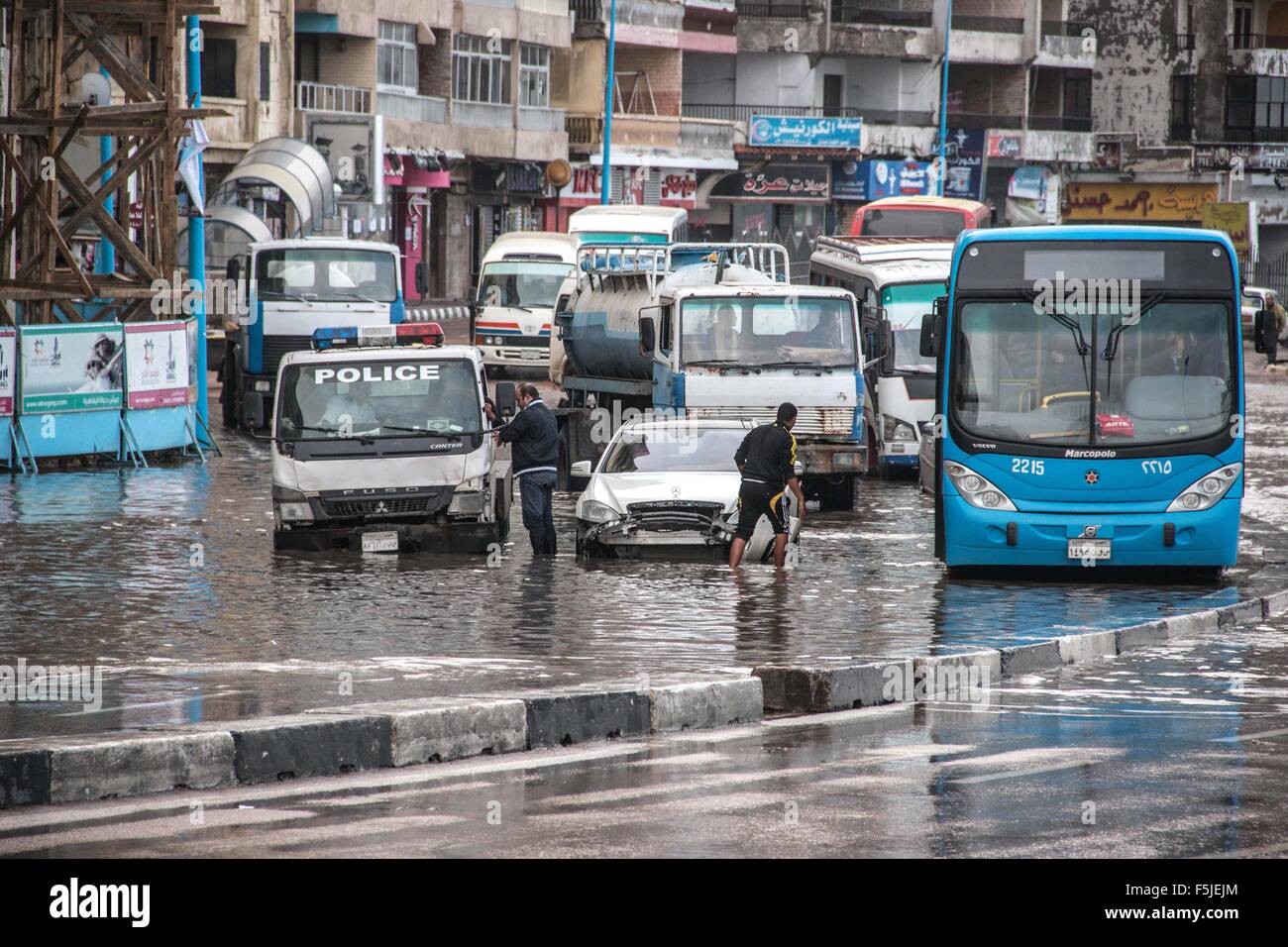 Alexandria, Egypt. 5th Nov, 2015. Egyptians walk in a flooded road following heavy rain storm, in Alexandria, Egypt. Eleven people were killed in floods in Beheira province north of Cairo, a security source said, and authorities evacuated 100 people from a village in the province as Egypt suffers from a second round of stormy weather in less than a month © Amr Sayed/APA Images/ZUMA Wire/Alamy Live News Stock Photo