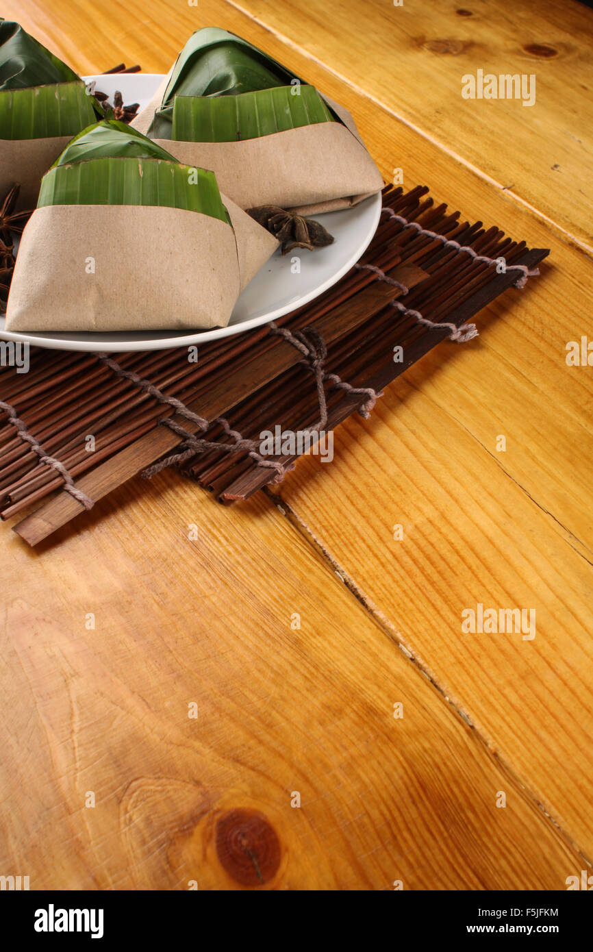 traditional fresh Malaysian nasi lemak packed with banana leaf in wood background Stock Photo