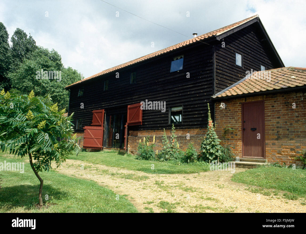 Exterior of a barn conversion with dark wood cladding Stock Photo