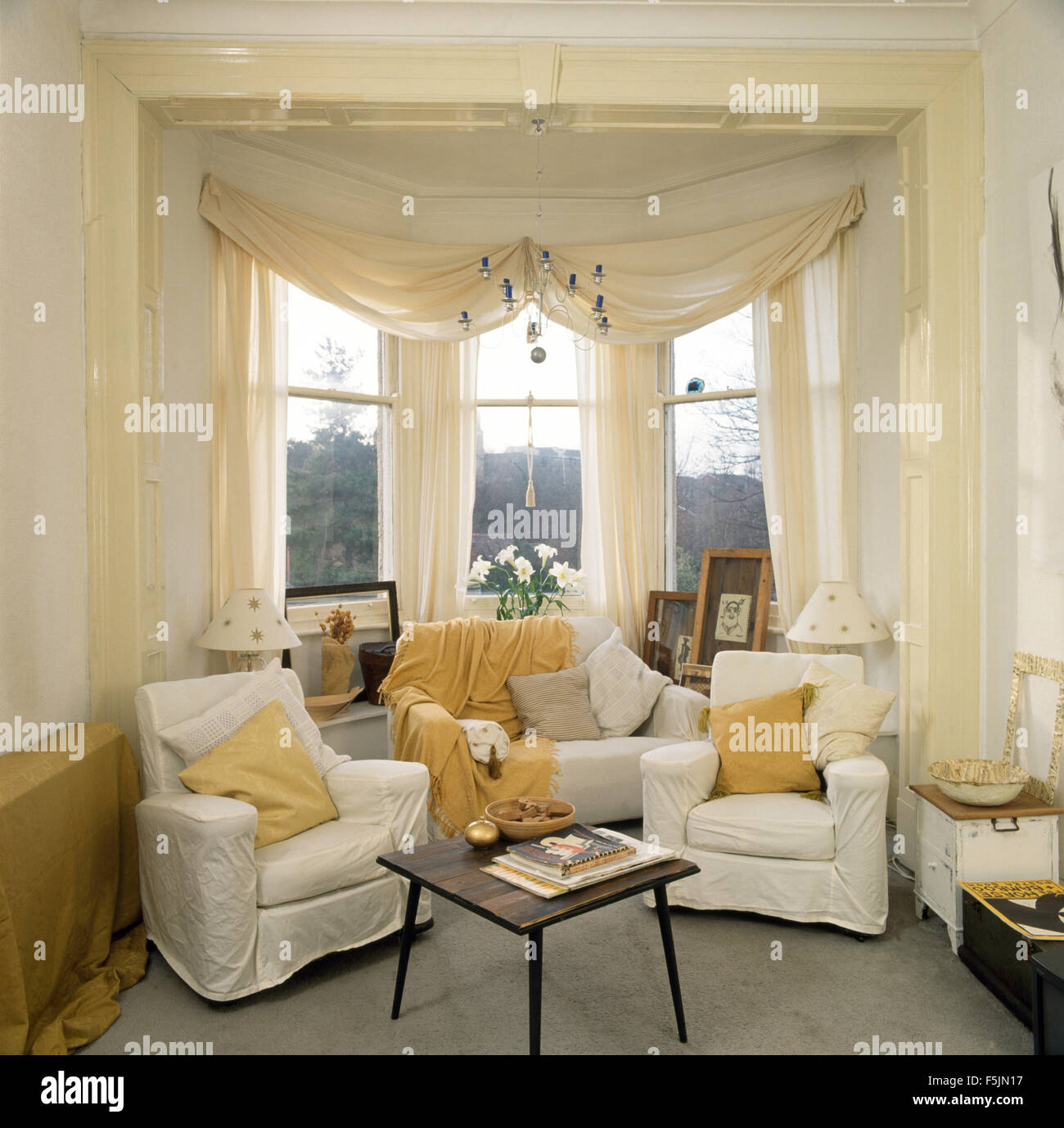 White Swagged Voile Curtains On Bay Window In A Nineties Living Room Stock Photo Alamy