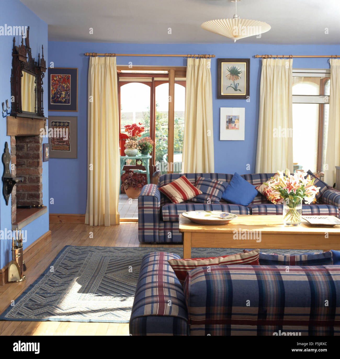 Plaid Sofas In A Blue Nineties Living Room With Cream Curtains On