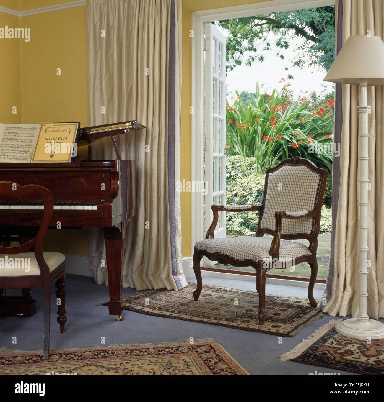 French Style Chair In Front Open French Windows With Cream Drapes