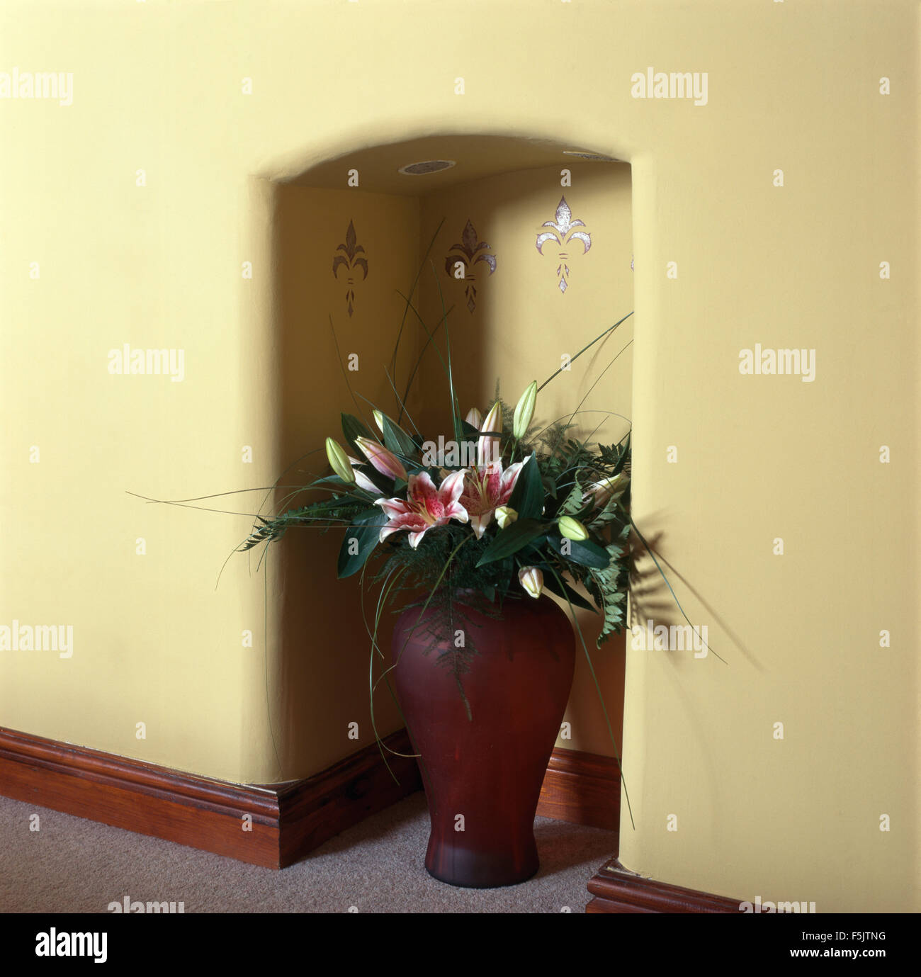 Vase of pink lilies in small alcove Stock Photo