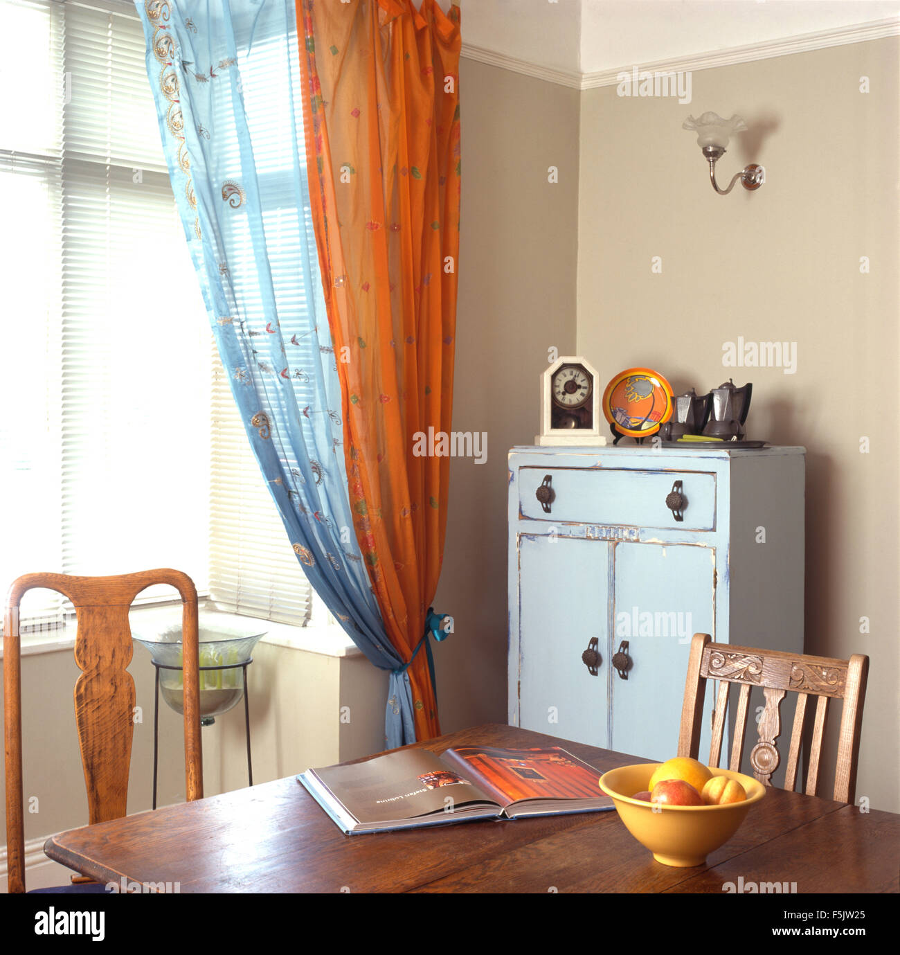 Orange And Blue Voile Drapes In A Nineties Economy Style Dining