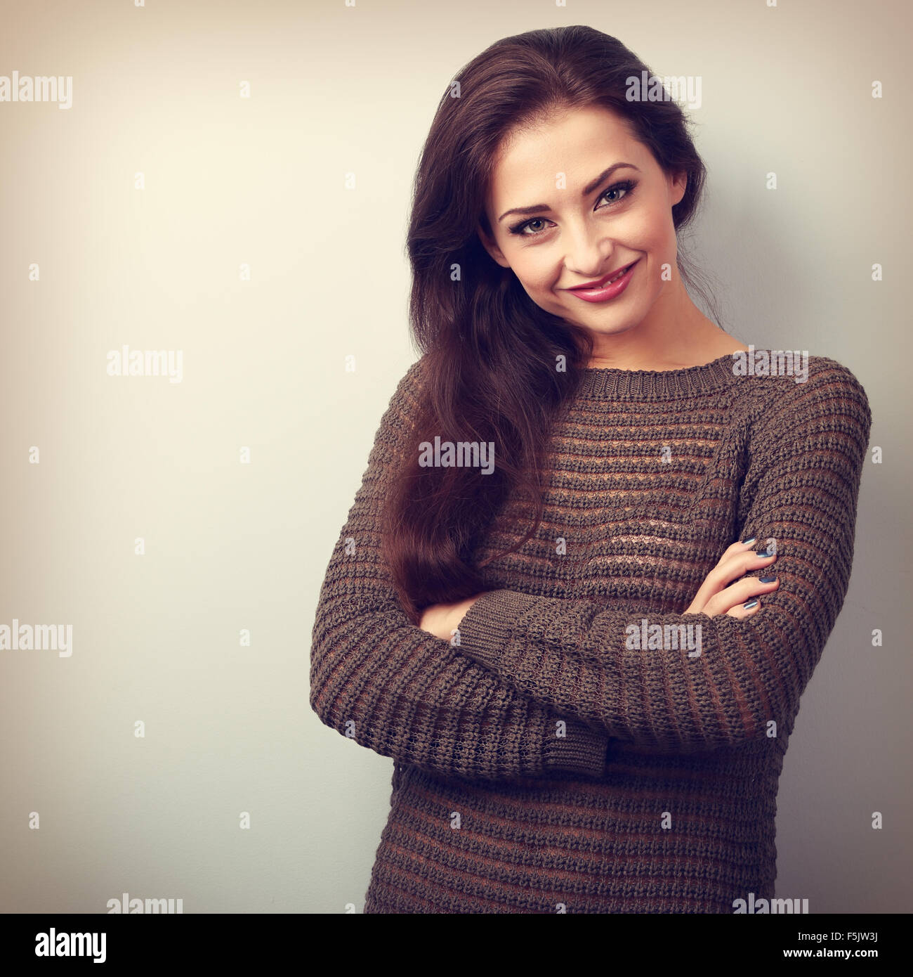 Happy young brunette woman smiling in warm sweater. Vintage portrait Stock Photo