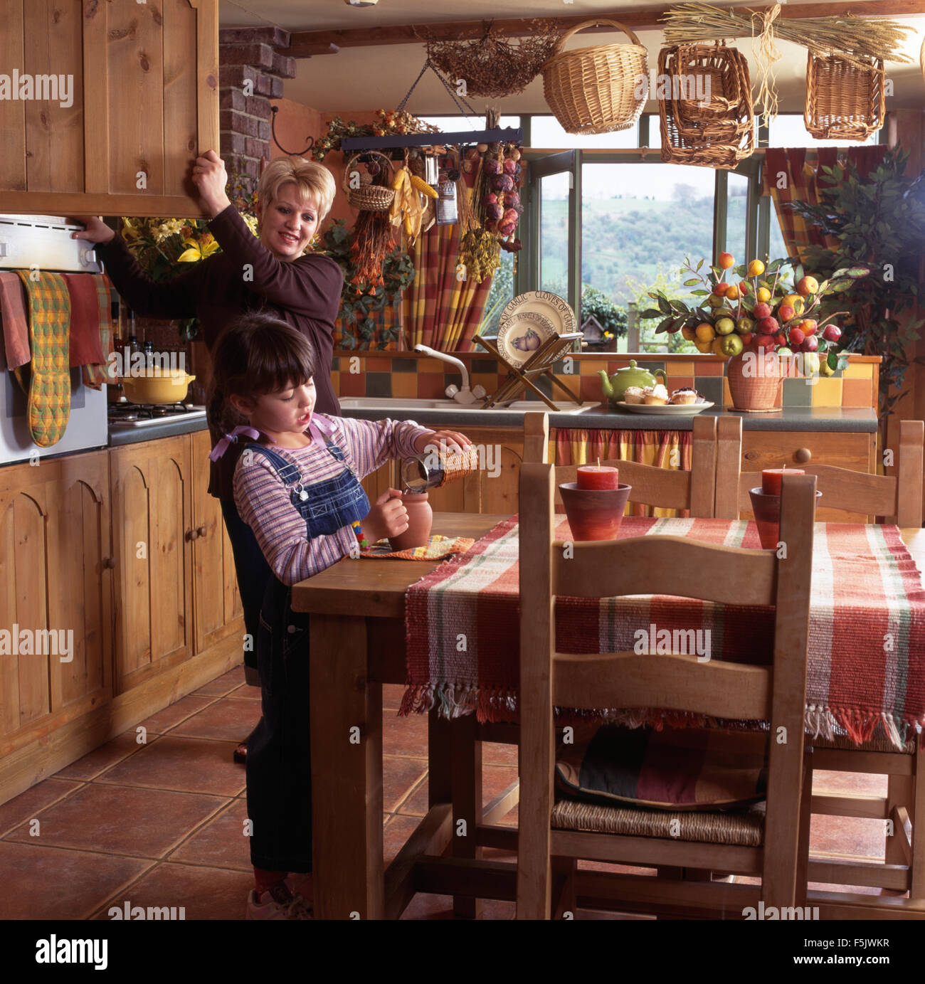 Mother and small daughter in a cottage kitchen         FOR EDITORIAL USE ONLY Stock Photo
