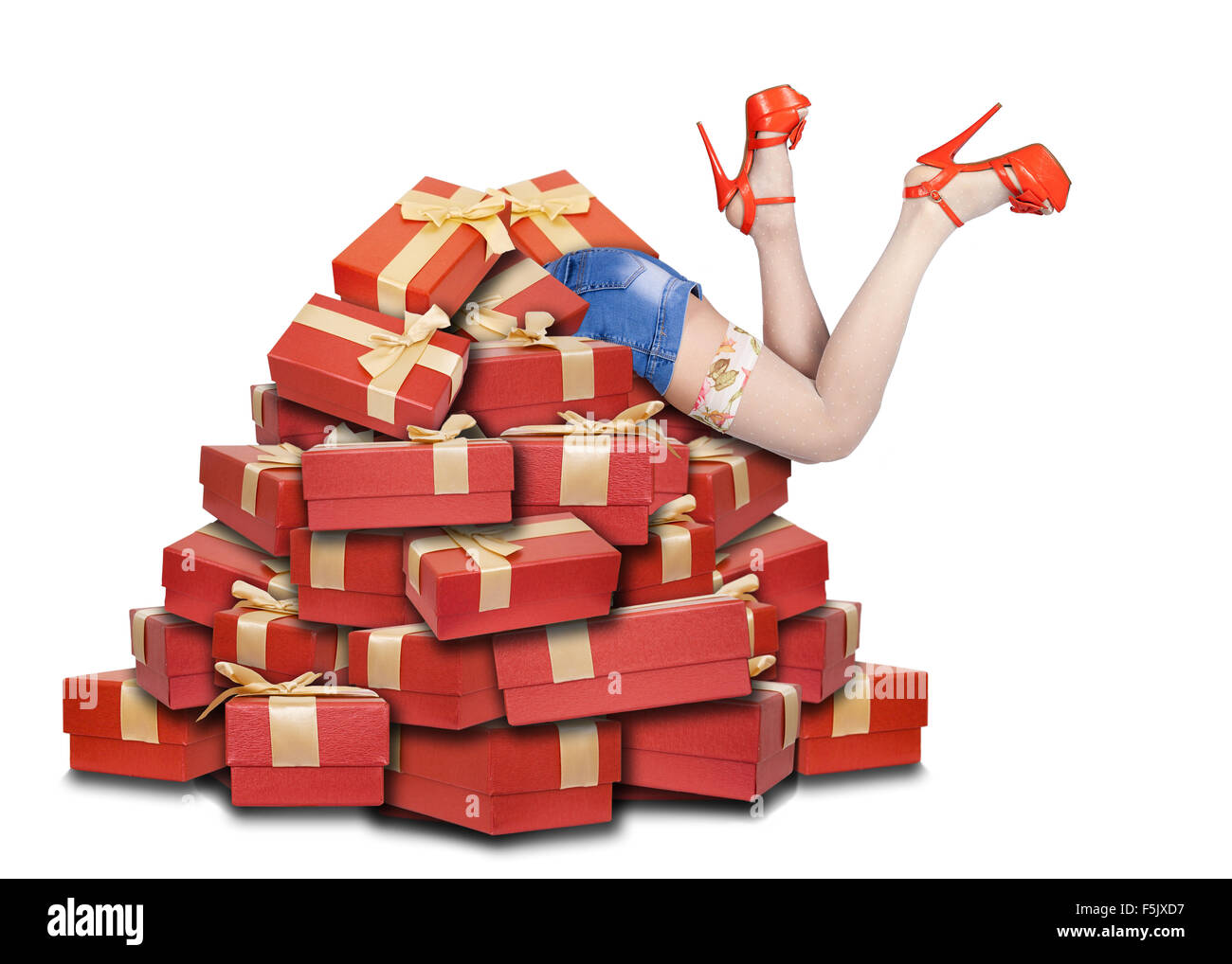 woman's legs sticking out from a pile of gift boxes Stock Photo
