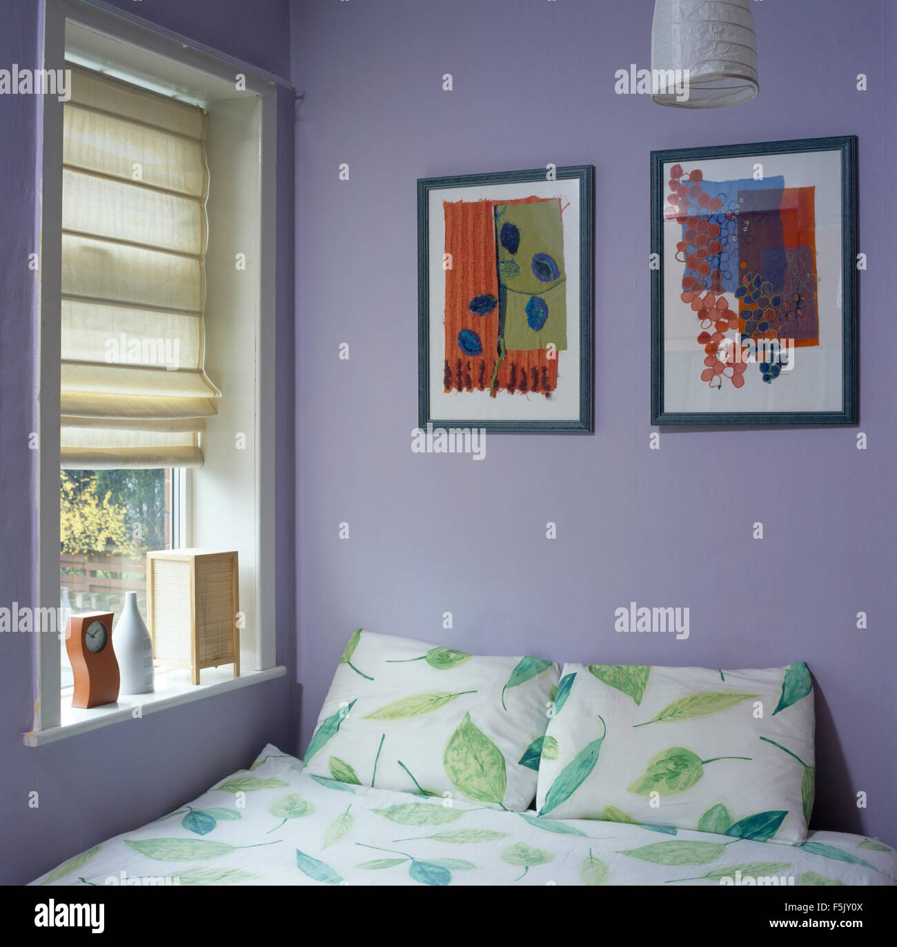 Pictures Above Bed With Leaf Patterned Bedlinen In A Mauve